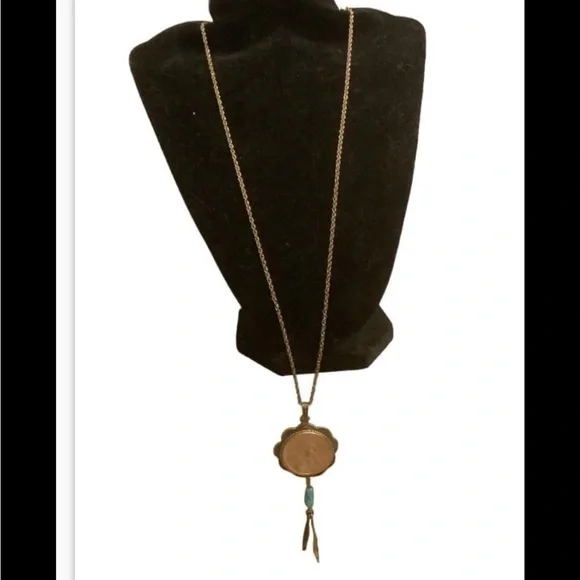 blue turquoise quarter dollar pendant hangs on a 24” gold tone necklace
